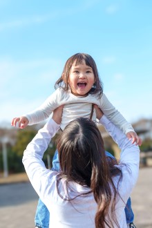 母親に抱きあげられた子どもの写真