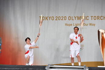 写真：トーチキスポーズをとる溝口　敬二（みぞぐち　けいじ）さんと北川　光（きたがわ　ひかる）さん