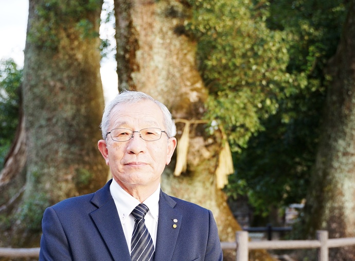 写真：春日神社のクスノキの前に立つ森さん