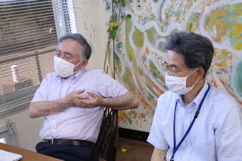 室内で話す長野理事長(左)と大久保事務局長(右)の写真