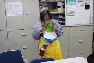 写真:エプロンに布のぬいぐるみを付けて大きなカブを説明する