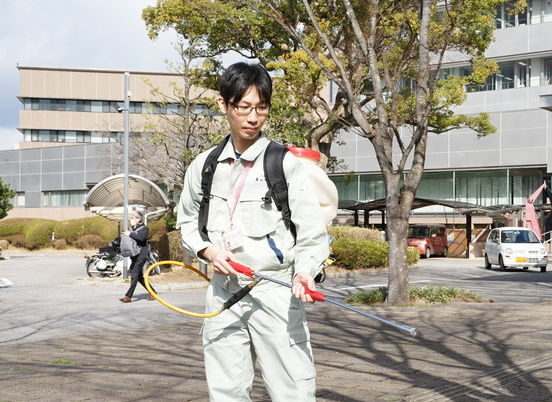 写真:消毒作業の様子を再現する平野主任