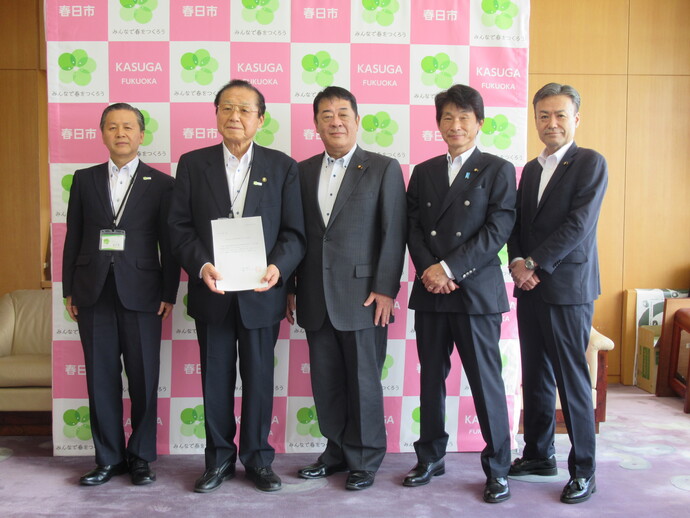 写真:議長から市長へ提言書を手渡す様子(市長や議員などの集合写真)