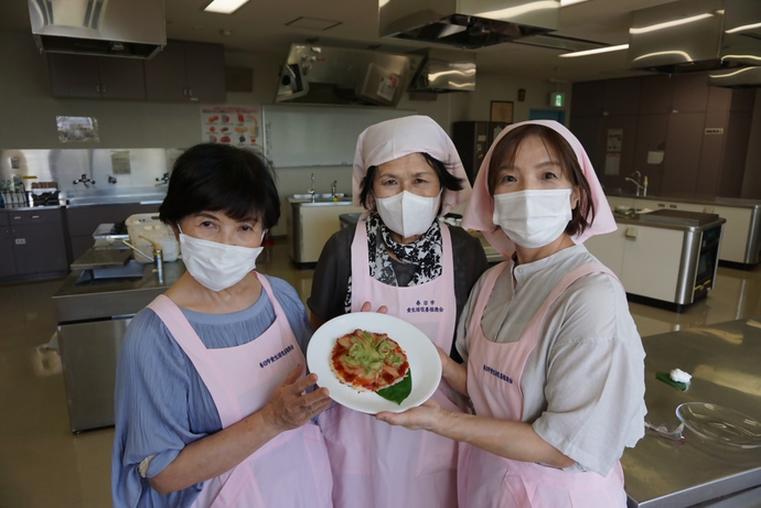 写真：ライスピザを持った春日市食生活改善推進会の皆さん