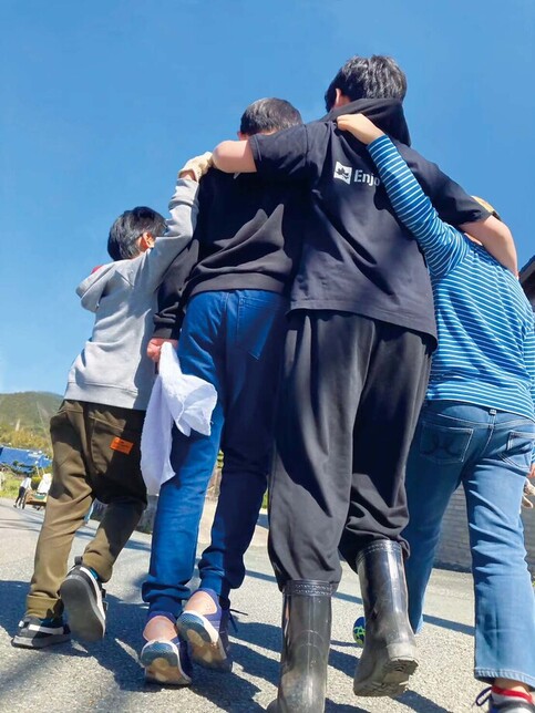 写真:肩を組んで外出先から帰る子どもたち
