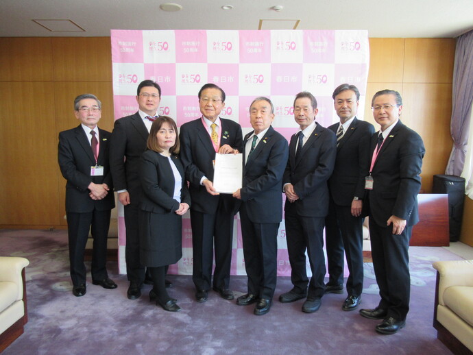 写真:議長から市長へ提言書を手渡す様子(市長や議員などの集合写真)